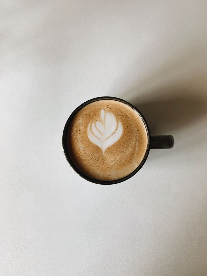 A flat white seen from directly above on a pale table.